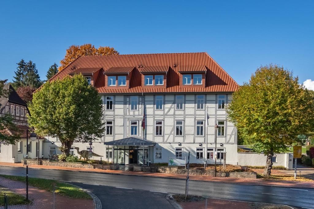 Bad Rehburg拜德雷布尔格公园酒店的一座白色的大建筑,有红色的屋顶