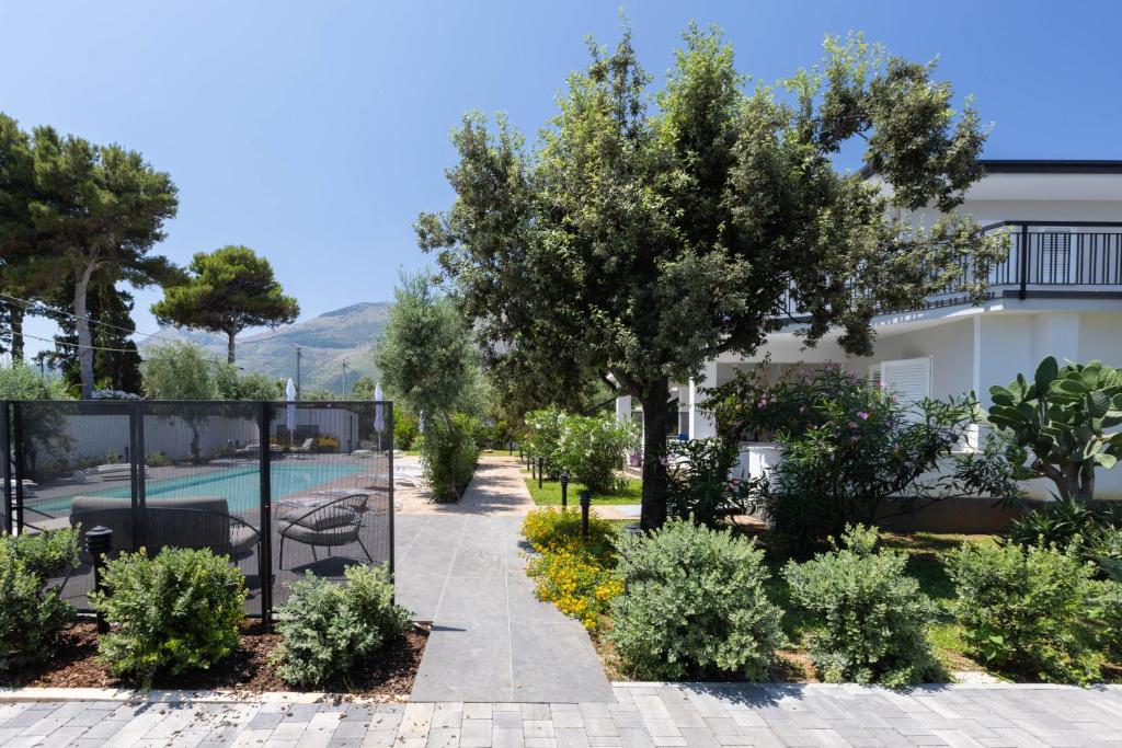 卡里尼Sweet Sicily Apartments的一座种植了树木的花园和一个游泳池