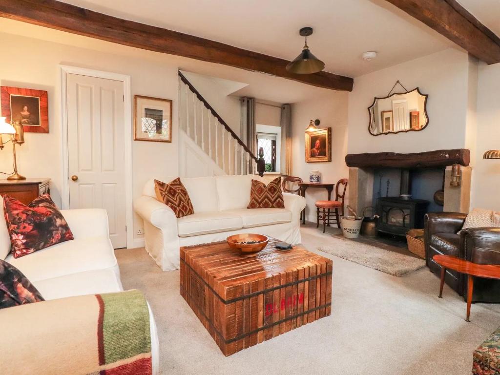 Barrowford17th Century 2-bed/bath period cottage的客厅配有白色家具和壁炉