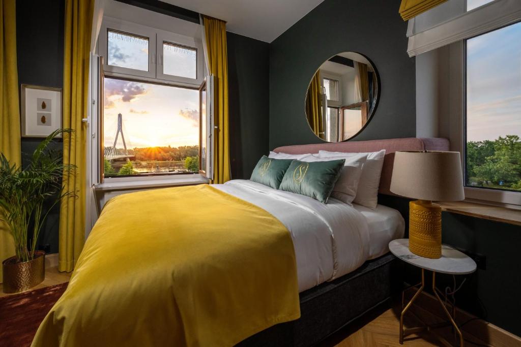 华沙Sava Boutique Hotel的一间卧室配有一张带黄色毯子和窗户的床