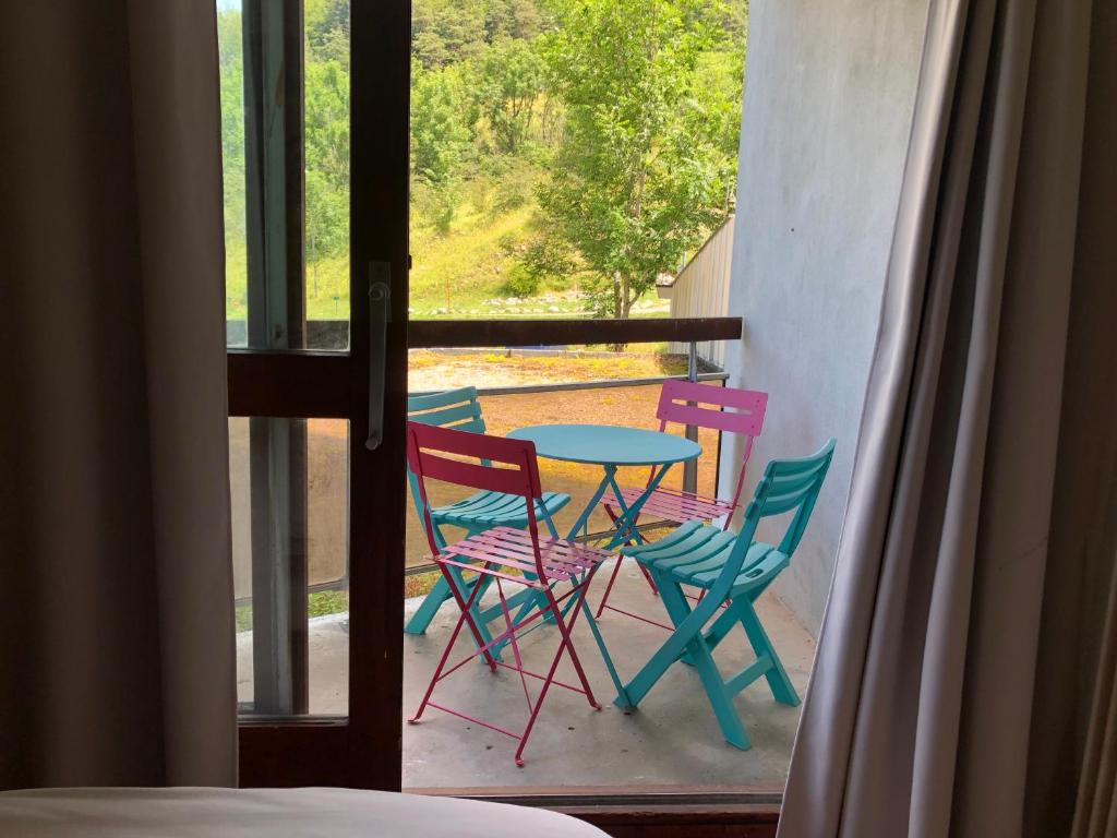 维拉尔-德朗Studio au pied des sentiers的阳台配有桌椅,享有美景。