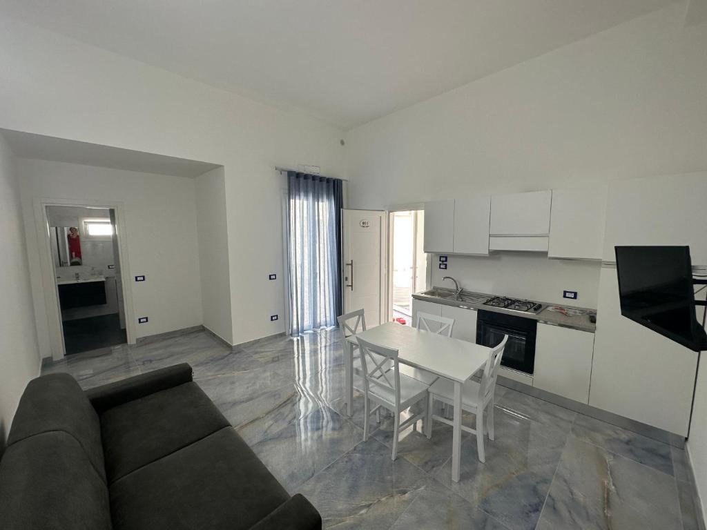 切萨雷奥港ALG Apartments con Parcheggio的带沙发和桌子的客厅以及厨房。