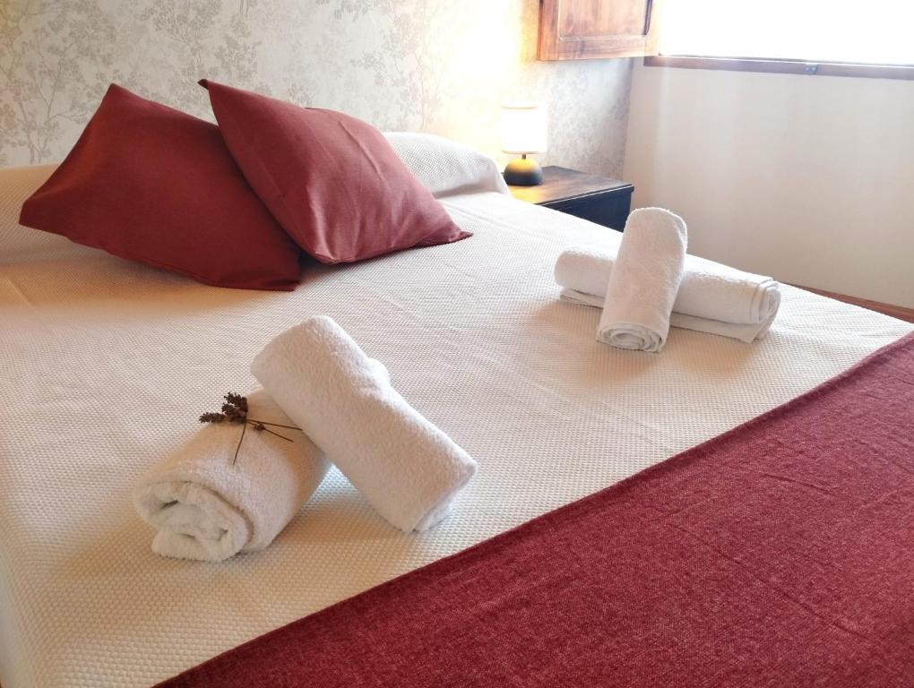 卢戈Casa Aldea de Abaixo的白色床上的2条毛巾和枕头