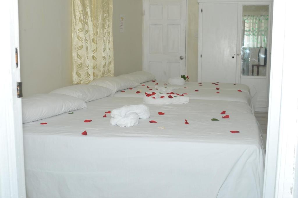 卡斯特里山景旅馆的一张白色的床,上面有红色玫瑰花瓣
