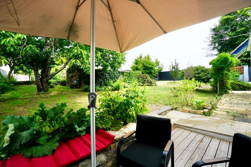 普洛埃默Logis Magnolia的露台设有遮阳伞和躺椅。