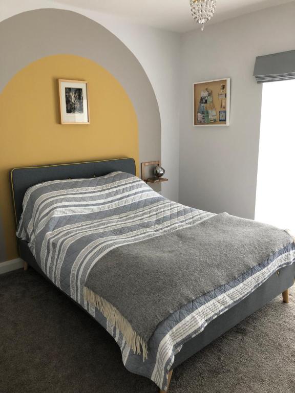 伯肯黑德Woodcliff的一间卧室配有带条纹毯子的床