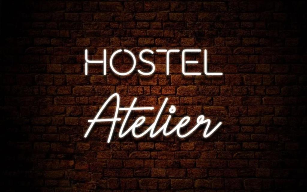 莱什诺Atelier Hostel的砖墙上说得更高一点的 ⁇ 虹灯标志