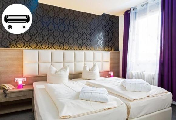 斯图加特巴伐利亚慕尼黑高级酒店的一间卧室配有两张带白色床单的床
