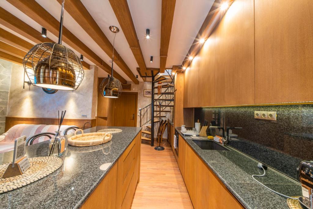 拉兹洛格Pirin Golf&Spa Apartment 17的一个带木制橱柜和黑色台面的大厨房