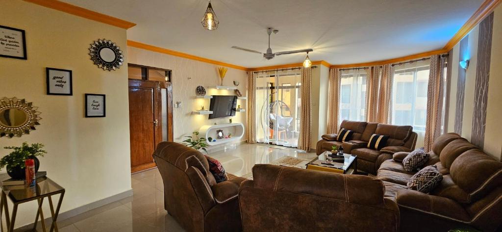 蒙巴萨Betty Homes的客厅配有两张沙发和一台电视机