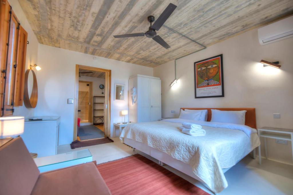 MunxarIndependent Old House in Gozo With Modernized Interior的一间卧室配有一张床和吊扇