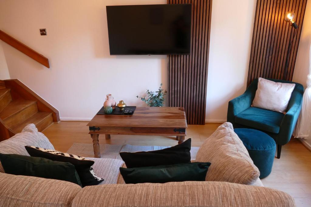 WarmleyHome in Longwell Green的带沙发、桌子和电视的客厅