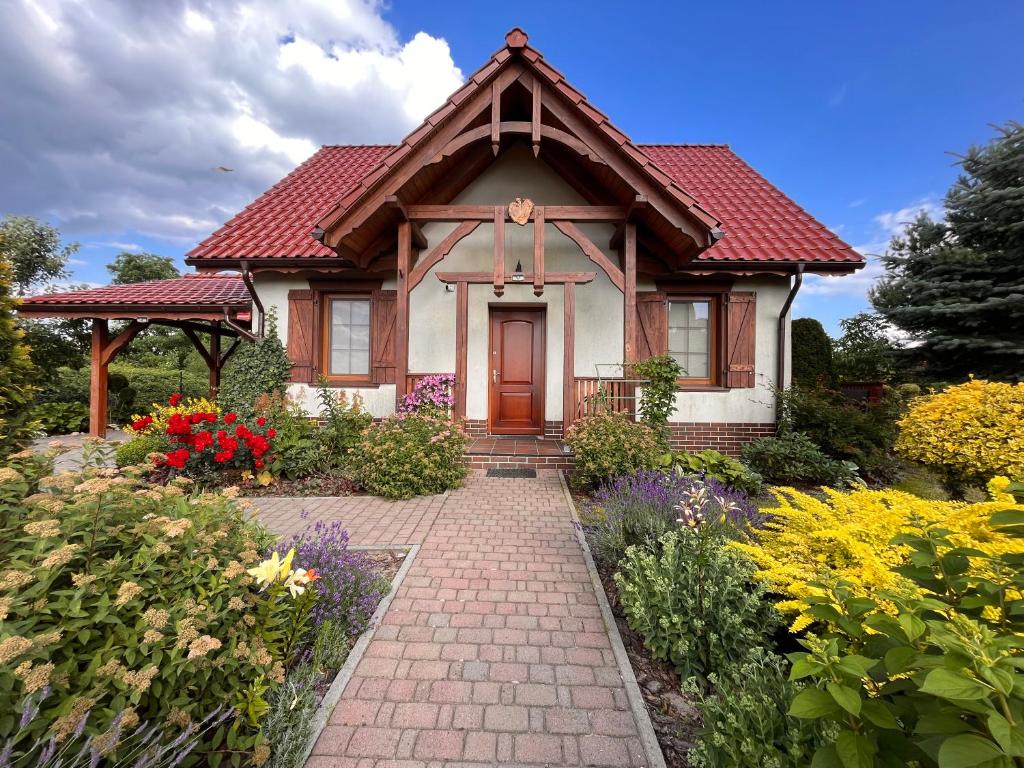 科贝拉古拉Ignacówka的一间有红屋顶和砖砌走道的小房子