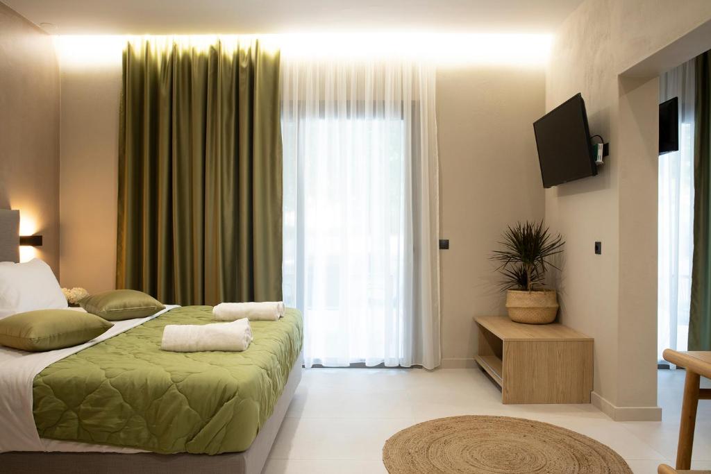 帕拉利亚潘塔利莫诺斯Olympus Suites的一间卧室设有一张床和一个大窗户