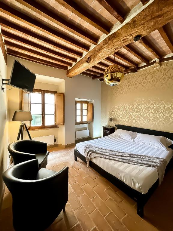 圣奎里科-多尔恰Locanda In Piazzetta - Casa in Centro Storico的一间卧室配有一张床、一台电视和椅子
