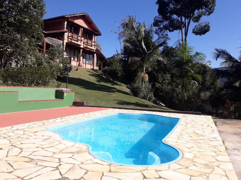 新弗里堡Casa com churrasqueira piscina privativa em São Pedro da Serra - Perto de Lumiar的房屋前的游泳池