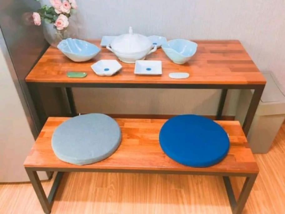 济州市SoGoBe Pension的木桌,上面放着碗和盘子