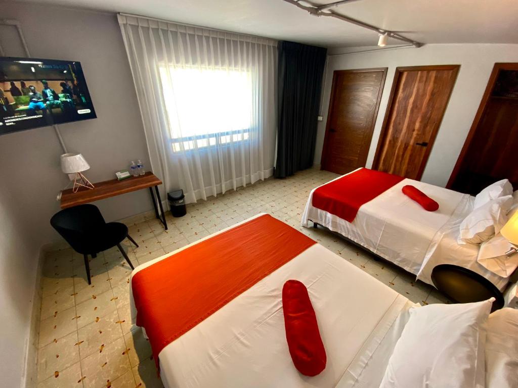 马特瓦拉Hotel El Pedregal的酒店客房 - 带两张带红色枕头的床