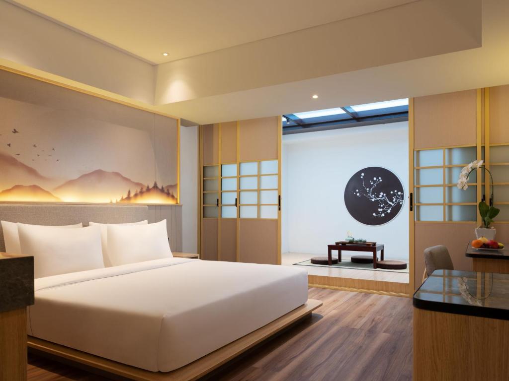 万隆Hotel Santika PasirKaliki的卧室设有一张白色大床和一扇窗户。
