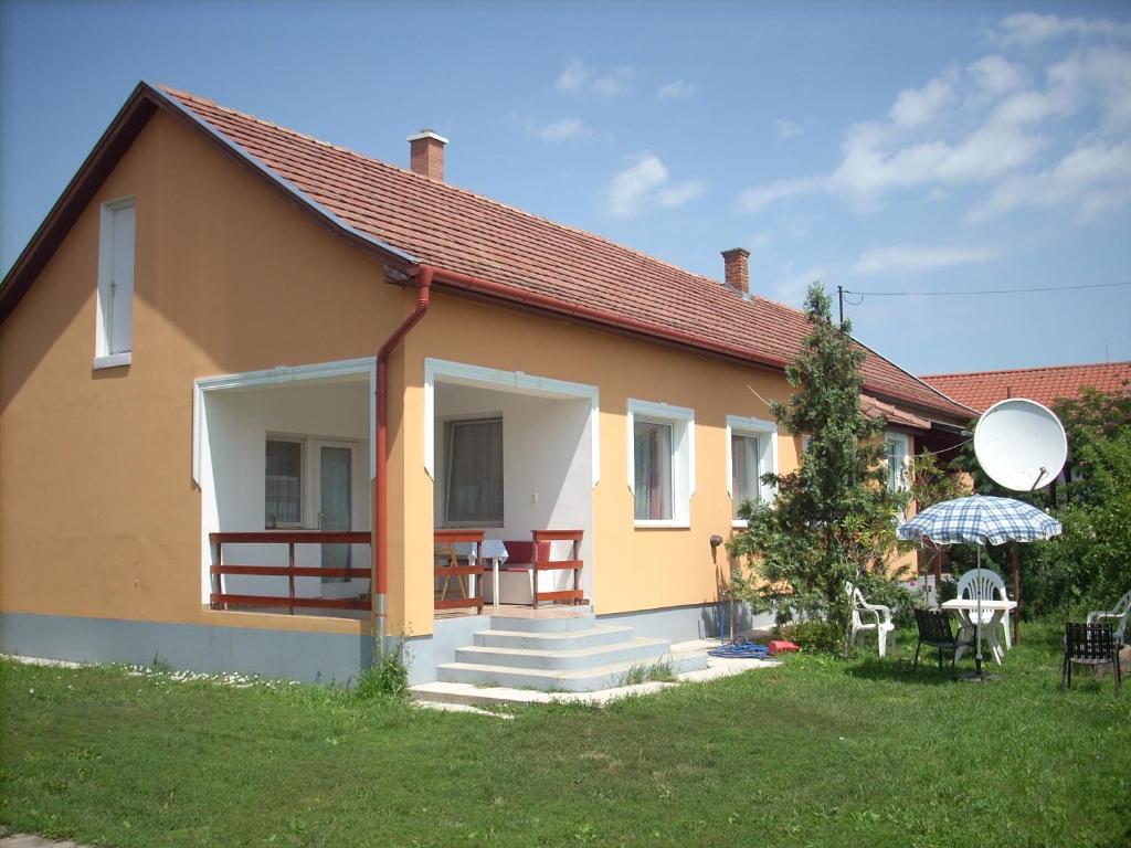 奥巴曹洛克Abádi Karmazsin ház的一座黄色的小房子,设有楼梯和庭院