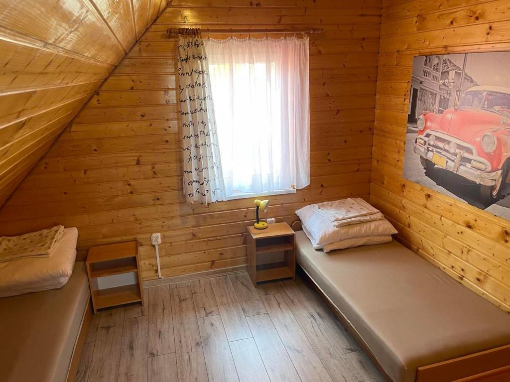 德兹维济诺Domki letniskowe Ibiza的小木屋内带两张床的房间