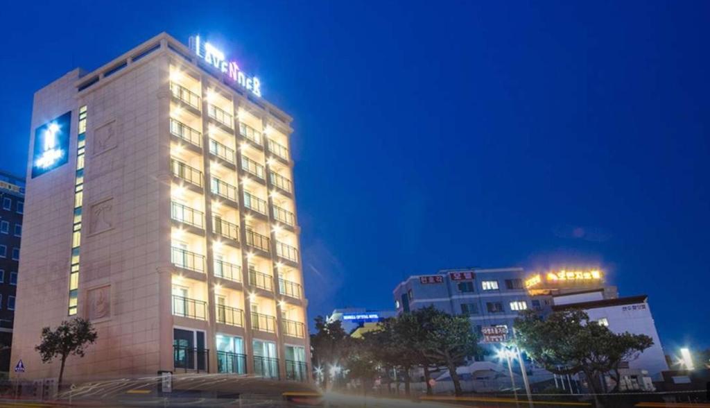 西归浦市Jeju Lavender Hotel的一座建筑物,上面有夜间标志