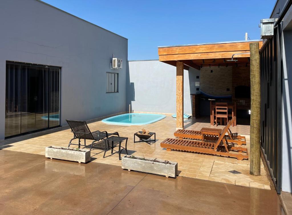 布罗塔斯Cantinho Estrelado - Casa automatizada com ALEXA的庭院设有游泳池、桌子和椅子。