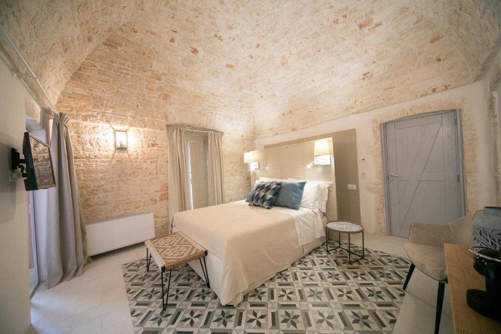 阿尔贝罗贝洛San Marco Boutique Rooms的砖墙间内一间卧室,配有一张床