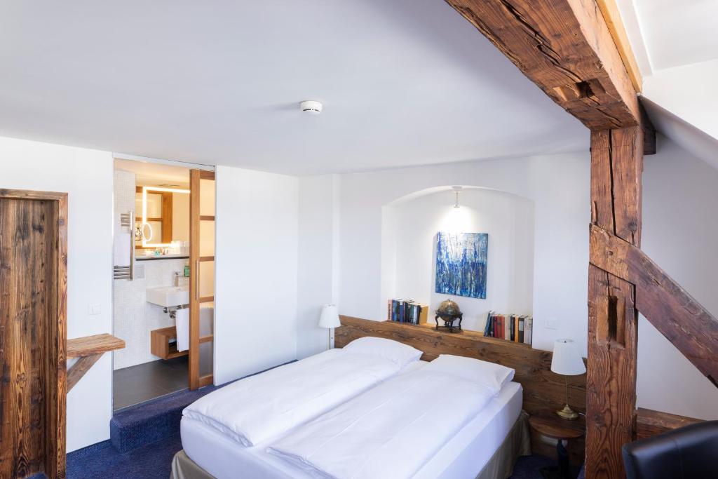 沙夫豪森Sorell Hotel Rüden的卧室配有一张白色大床和木制床头板