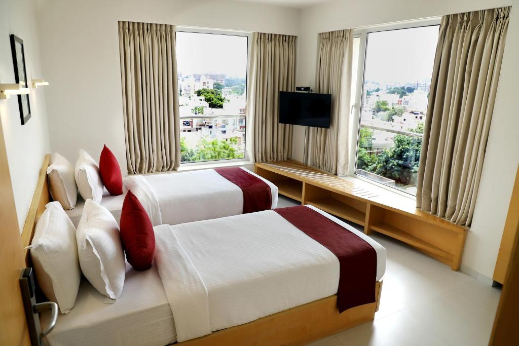 拉杰果德Patria Suites的酒店客房设有两张床和窗户。