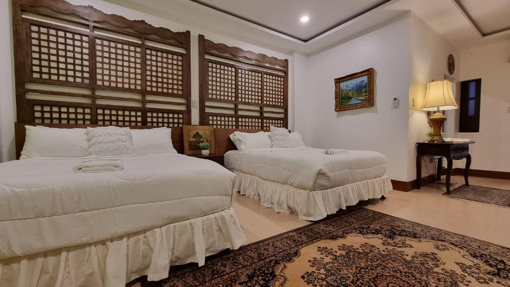 杜马格特Residencia Orlina的一间卧室配有两张床和一张带台灯的桌子