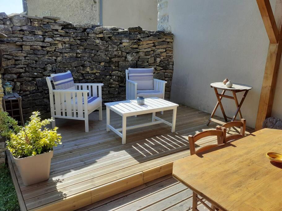 MontrodatLa cabane au fond du jardin的庭院设有两把椅子和一张桌子,还有石墙