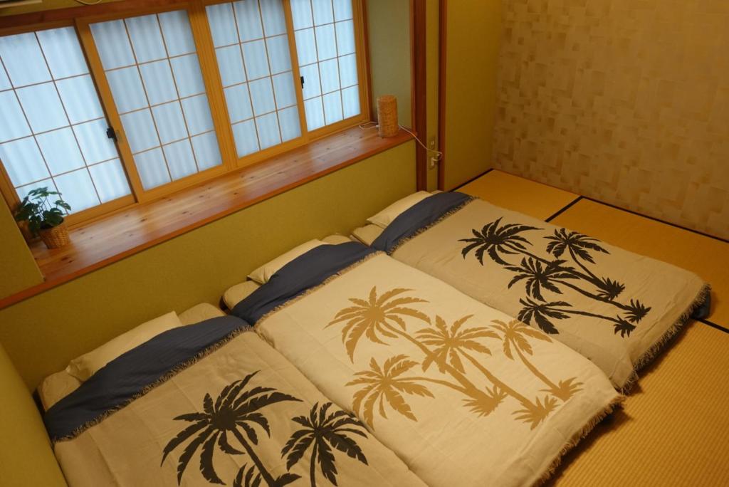 京都ALOHADAYS Kyoto的一间卧室配有两张棕榈树床。