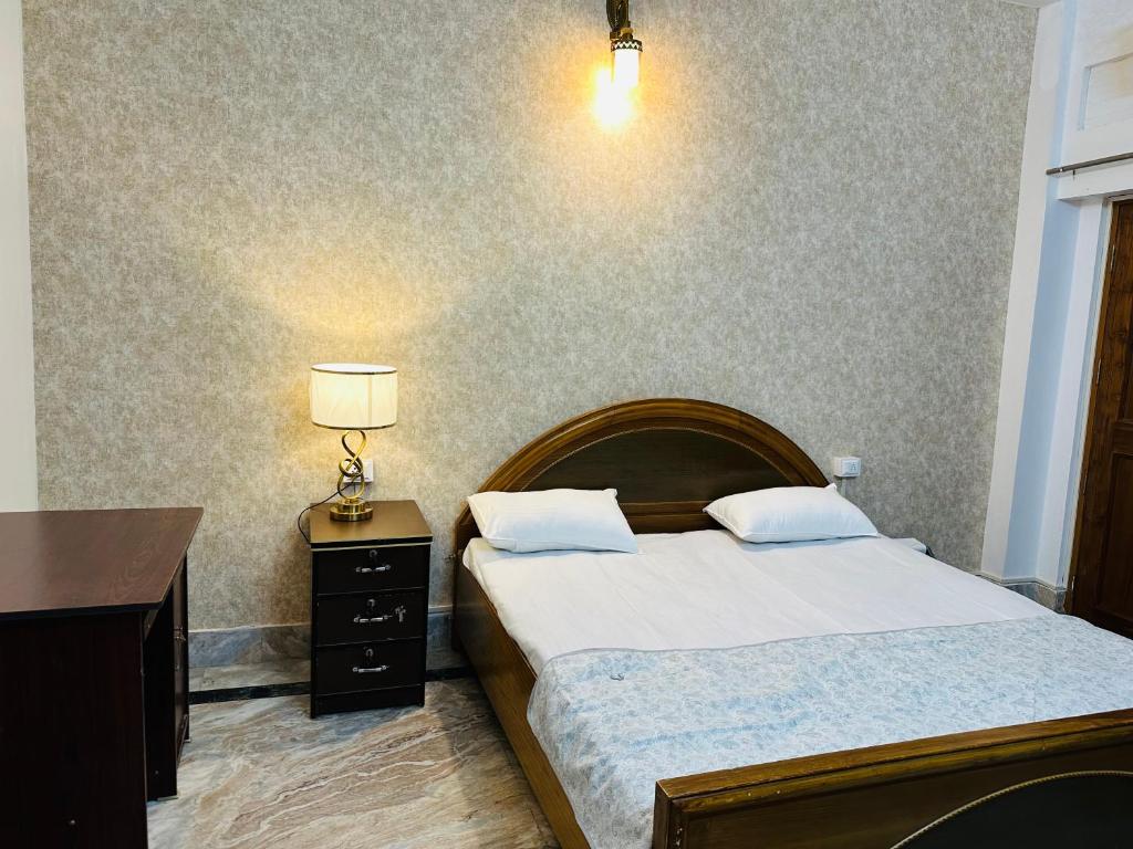 瓦拉纳西Paridhi的一间卧室配有一张床、一张桌子和一盏灯