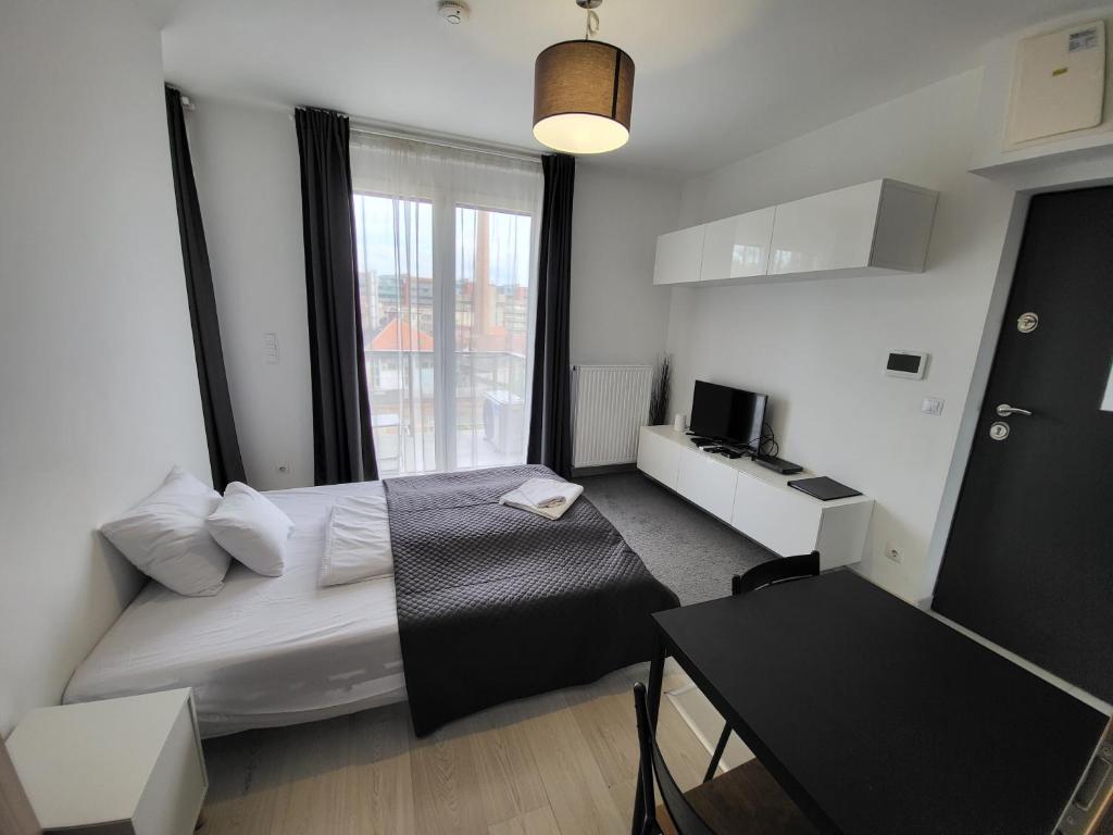 布达佩斯SDP Meder B401 Apartment的一间卧室配有一张床、一张书桌和一个窗户。