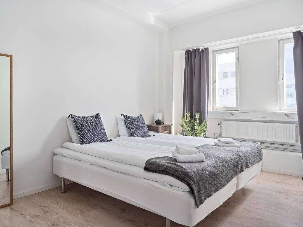 Norsborg斯拉格斯塔斯特兰德公寓式酒店的白色卧室配有一张大白色的床和毯子