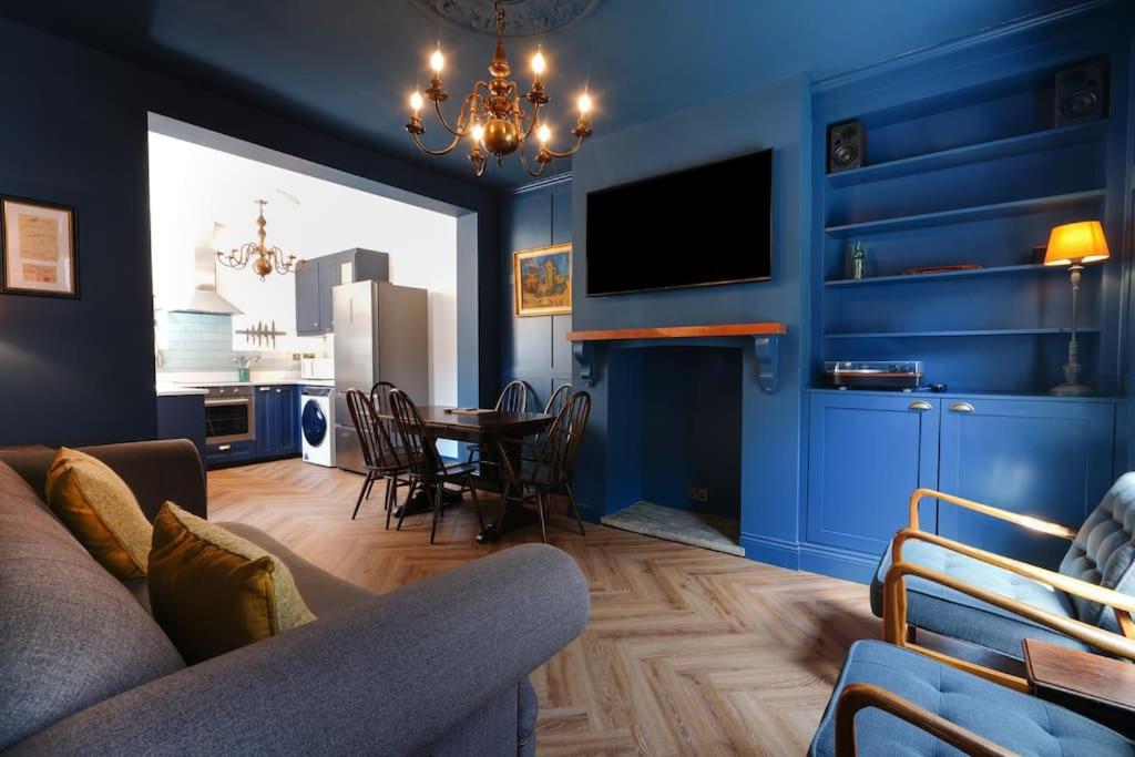 麦克尔斯菲尔德4 Bedroom Town House的客厅拥有蓝色的墙壁,配有桌椅