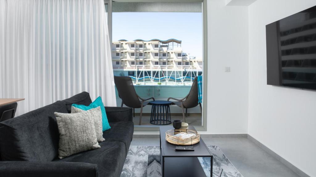 埃拉特Amazing big studio sea view apartment - By Edom的客厅配有沙发和桌椅