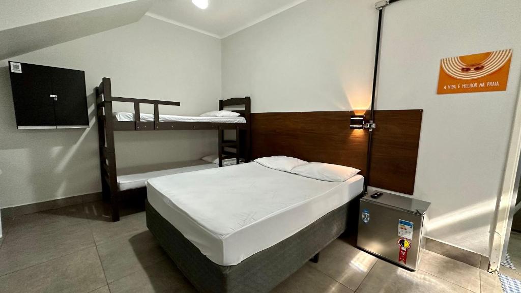 瓜鲁雅Suíte n° 03 - Praia das Pitangueiras的小房间设有一张床和一张双层床