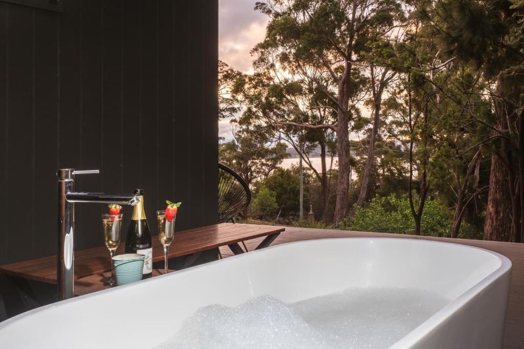 Simpsons BayBlyth Retreat, Bruny Island的带浴缸的浴室,享有树林美景