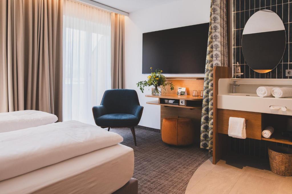 SatteinsTILL Naturhotel - Self-Check-In的酒店客房,配有两张床和椅子