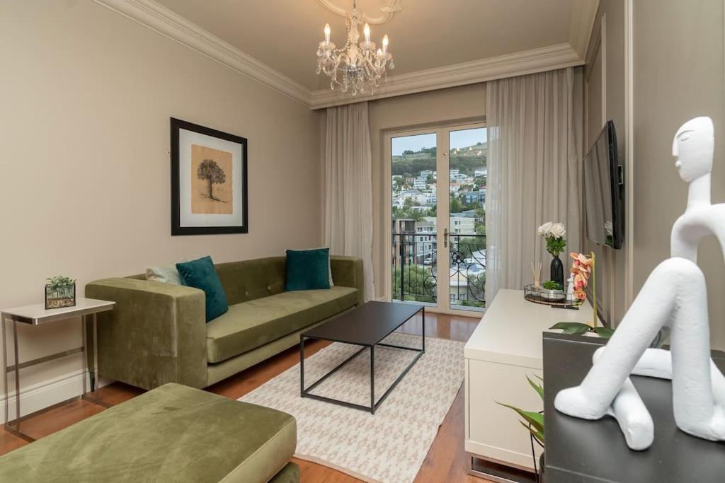 开普敦Green Point Luxury的客厅设有绿色沙发和窗户。