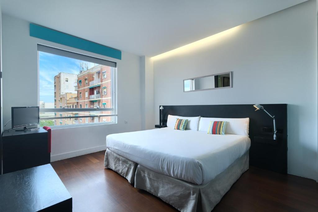 瓦伦西亚Sea You Hotel Port Valencia的一间卧室设有一张大床和一个窗户。