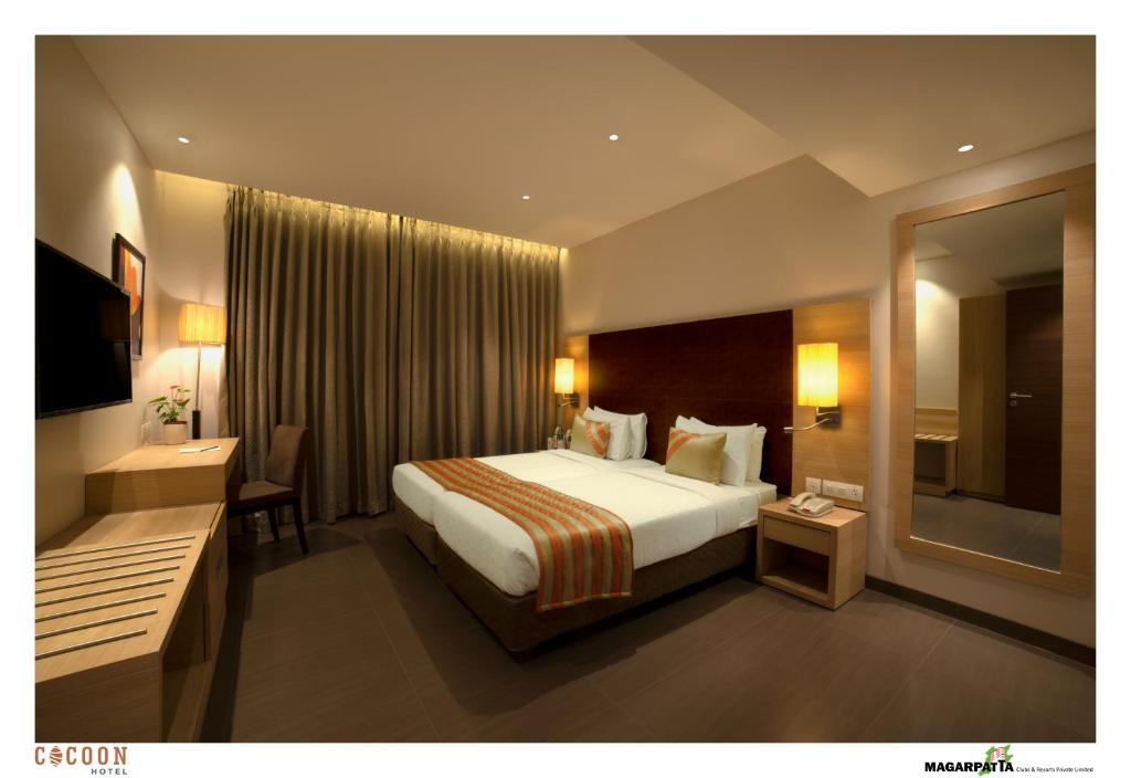浦那科昆酒店的配有一张大床和镜子的酒店客房