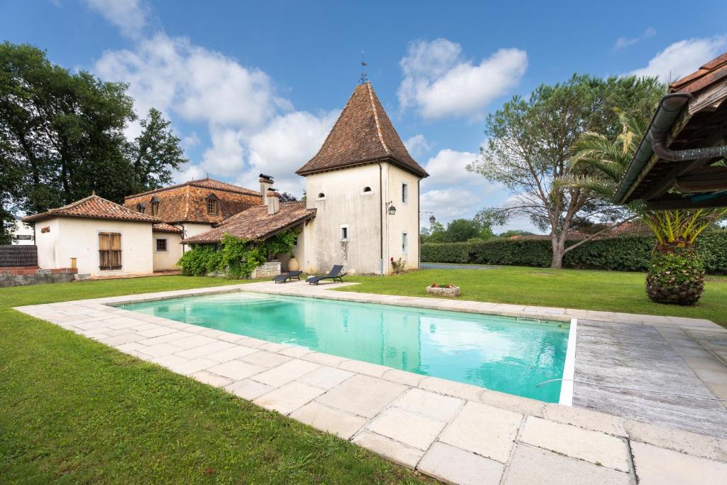 萨利耶德贝阿尔恩Lou Grit - Maison pour 10 avec piscine privée的大楼前带游泳池的房子