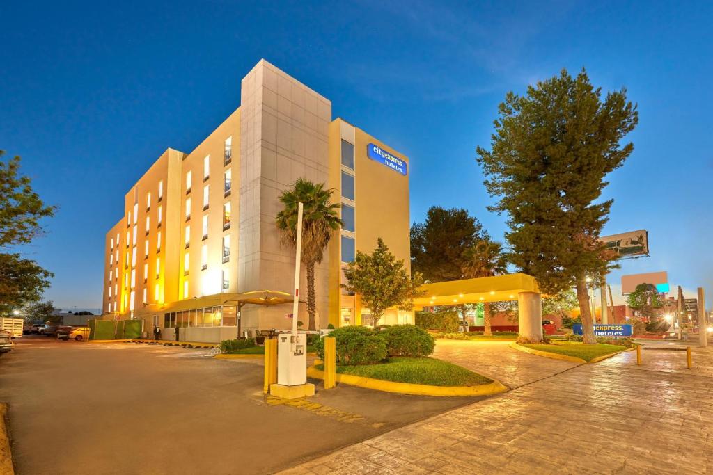 萨尔蒂约都市快车萨尔蒂洛诺特酒店的一座酒店大楼,前面有棕榈树