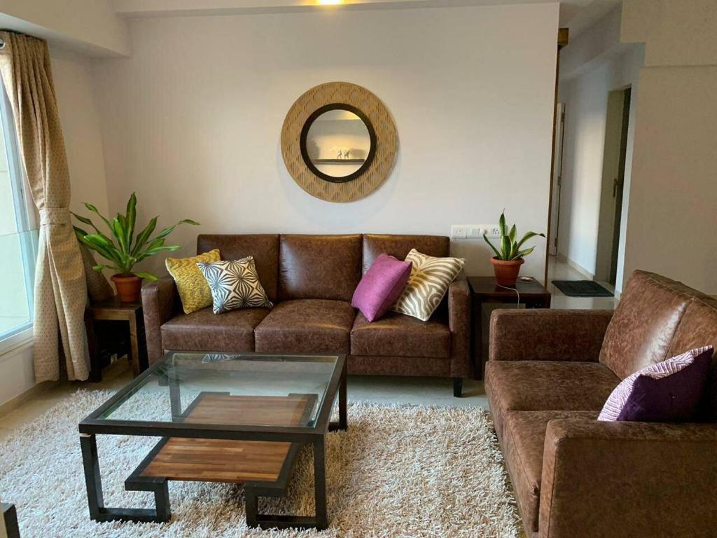 孟买Kanakia Paris D wing at BKC, Near Asian Heart Hospital, A Luxury Stay by Connekt Homes的带沙发和咖啡桌的客厅