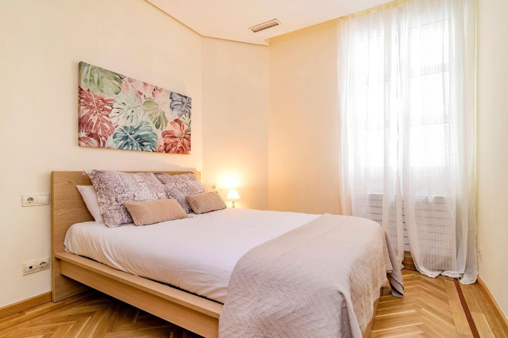 马德里Velazquez Suites的一间卧室设有一张大床和一个窗户。
