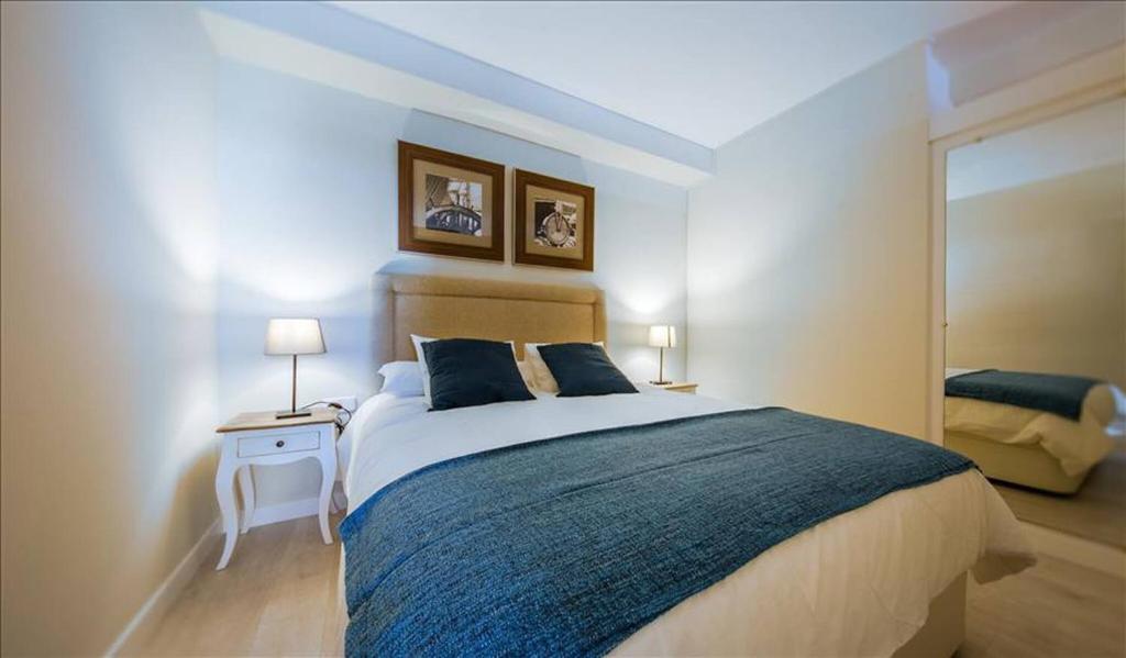 马德里科隆公寓的一间卧室配有一张大床和镜子
