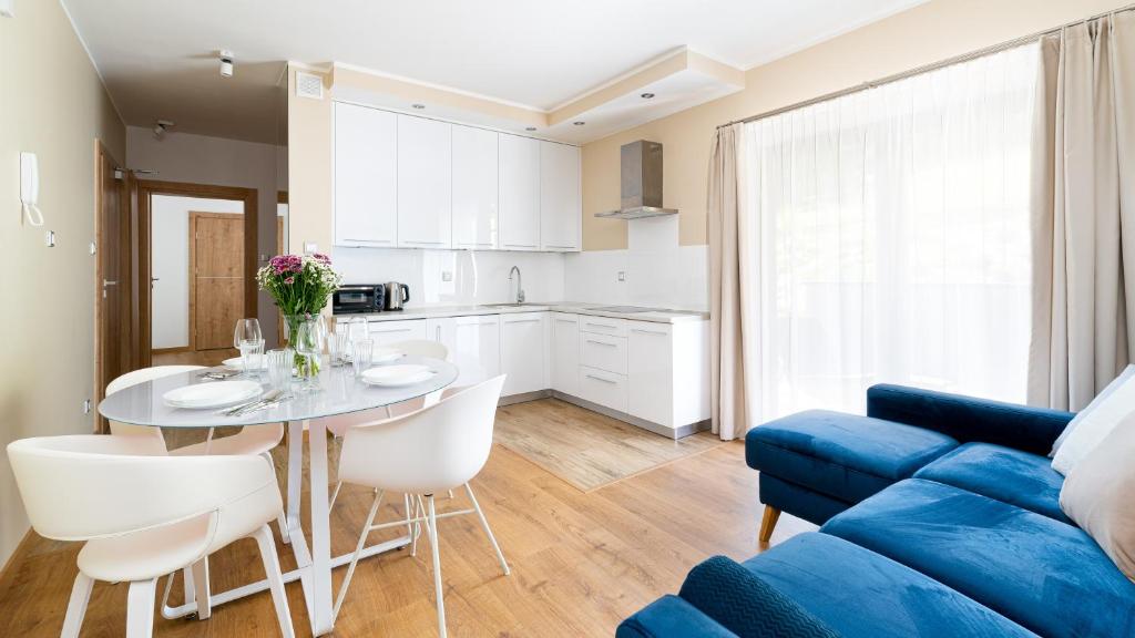 卡尔帕奇Apartamenty Sun & Snow Rezydencja Karkonoska的客厅配有桌子和蓝色沙发